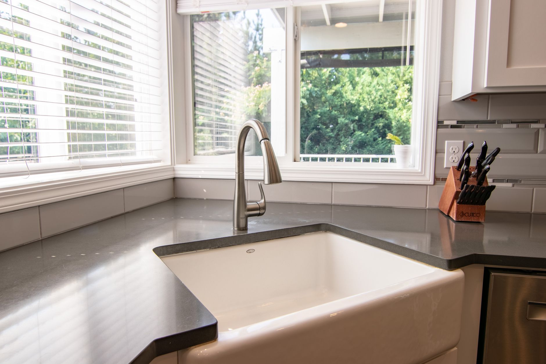 Kitchen sink with a stainless steel faucet beside a window